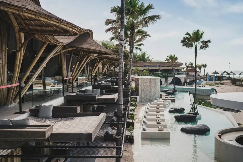 Bamboo beach club with daybeds, pool, and ocean view, showing different styles for Bali beach experiences.