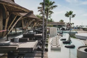 Bamboo beach club with daybeds, pool, and ocean view, showing different styles for Bali beach experiences.