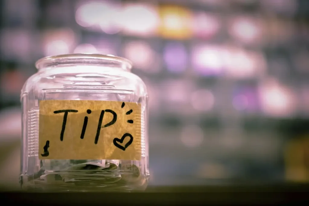 Tip jar with cash inside, illustrating tipping practices tourists may encounter in Bali.