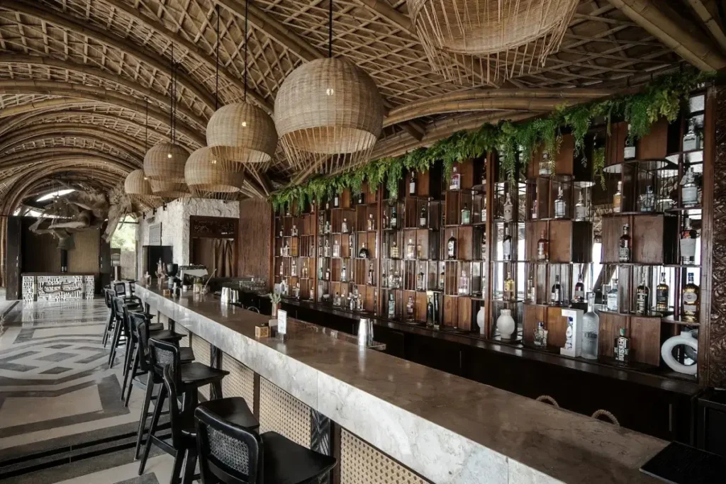 Area bar di Bali dengan deretan minuman dan tempat duduk untuk menikmati cocktails malam hari.