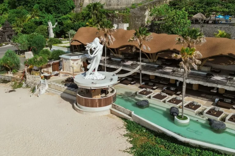 Beach club near Nusa Dua with pool, beach seating, and sunset relaxation atmosphere.