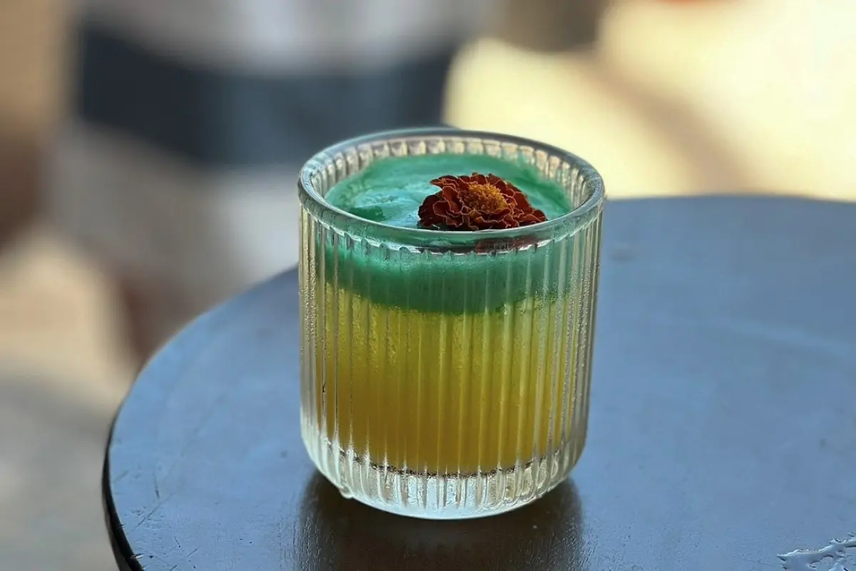 Colorful signature cocktail served in a glass, perfect for a relaxing beach club experience by the sea.